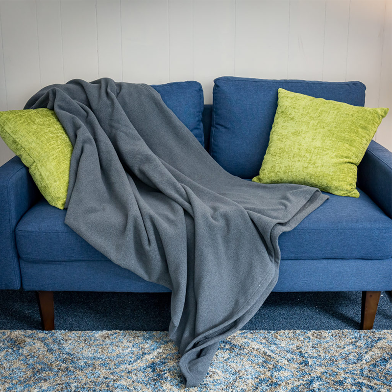 TrueLight Regenerative IR+FIR Blanket spread out on blue couch