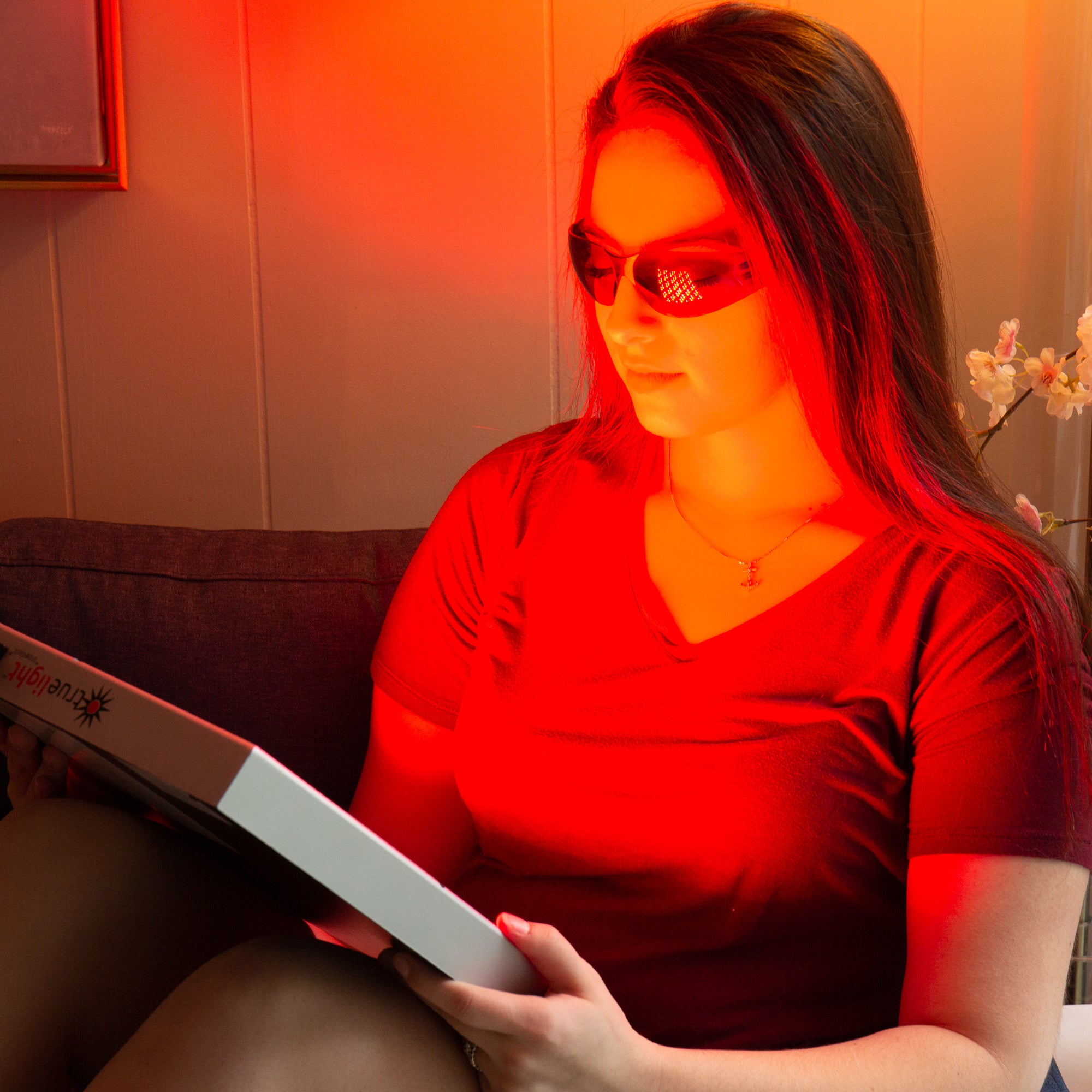 Woman wearing Calm Eye Shields while using TrueLight Energy Square Red Light Therapy