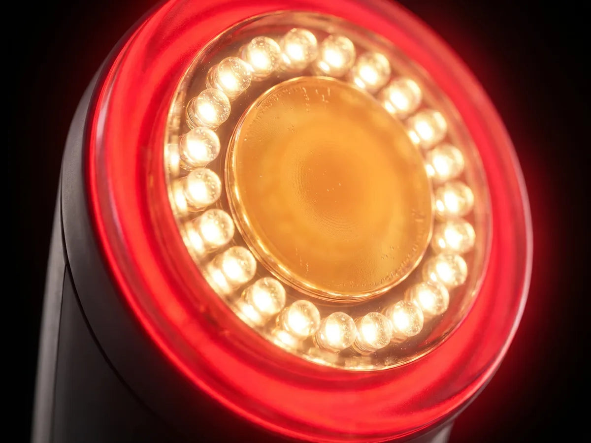 Close-up of the Perfectio X treatment head: red halo, a ring of warm LEDs, and a glowing amber glass center